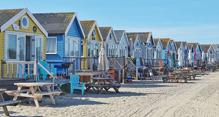 A row of colourful beach huts. 