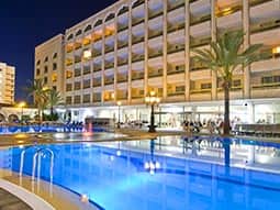 Exterior of Aparthotel Columbus building and outdoor pool, at night