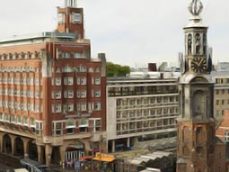 A clock tower in front of the NH Carlton Amsterdam building