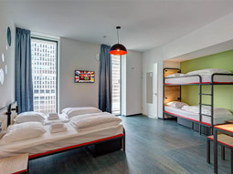 A spacious room with single beds and bunk beds at Meininger Amsterdam Amstel