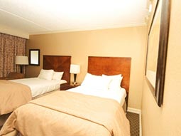 A hotel room with two single beds and bedside tables