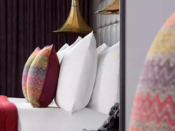 A close up of a bed with patterned cushions on at Hotel Indigo Cardiff