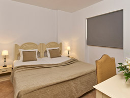 A king bed in a room with a dressing area at Cheerfulway Minichoro Apartments