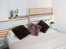 A close up of a bed with coloured cushions on in a room at Happy Apartments in Valencia