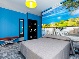 A king bed in a colourful room at JC Rooms Chueca