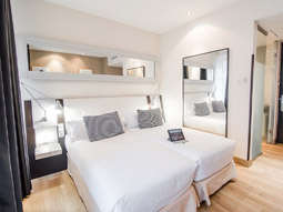 A double room with a large mirror at Petit Palace Chueca Hotel