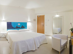 A king bed in a room with a desk area and large mirror at Hotel Florencio in Ibiza