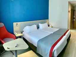 A double bed in a room with a bright blue wall and bedside tables at Holiday Inn Express Valencia-Ciudad las Ciencias
