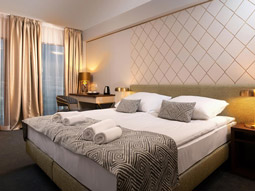 A king bed in a room with large windows and bedside tables at Globus Aparthotel 