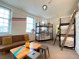 A room with a lounge area and two bunkbeds at The Admiral