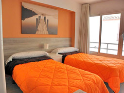 Two single beds with a bedside table between them at JSM Apartments Benalmadena