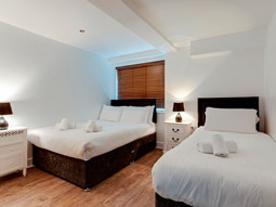 Two beds in a room with drawers at The Printworks Apartments