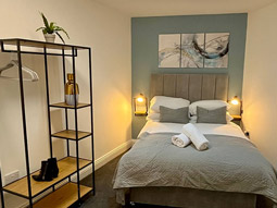 A bedroom at Ben's Place with a double bed and a large piece of wall art 