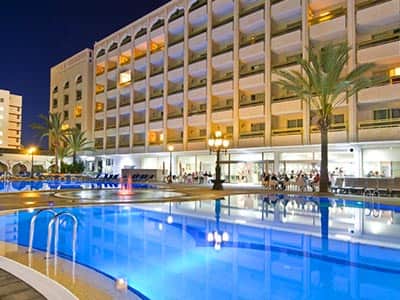 Exterior of Aparthotel Columbus building and outdoor pool, at night