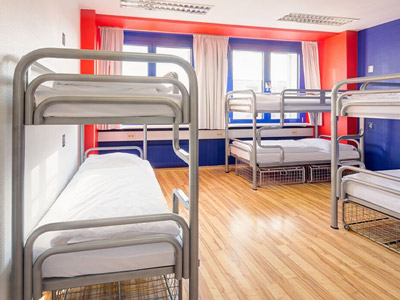 Three bunkbeds in a room with orange and blue walls at Generator Prenzlauer Berg