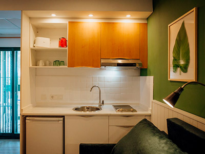 A kitchen area next to a bed at Palm Court