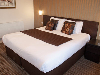 A double bed in a room with bedside lights at The Hop Inn in Bournemouth