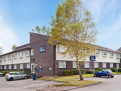 The exterior of Travelodge Chester Warrington Road with cars parked outside
