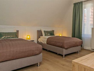 Two single beds in a room with warm lighting at Black Swan House in Gdansk