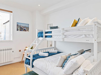 A single and double bunk bed with bright lighting in a room at Seaview Heights Apartment in Brighton