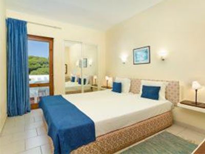 A king bed with a view of the city and surrounding landscape at Cheerfulway Ourasol Apartments