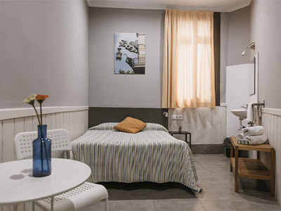 A double room with a small table and set of chairs at Pension 45 in Barcelona