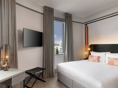 A double room with two windows that overlook the city of London at Hart Shoreditch Hotel in London
