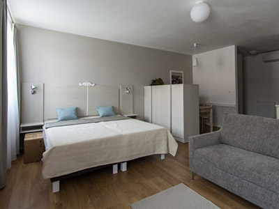 An open plan double room with a sofa and desk area at Venturian Apartments in Bratislava