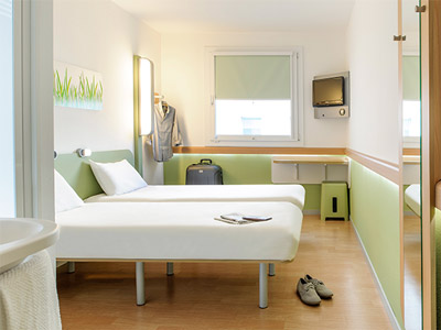 A green themed room with two single beds in it at Ibis budget Hamburg St Pauli Messe in Hamburg - Rank #10