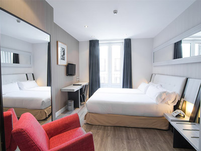 A large bed in a room with a big mirror and TV at Petit Palace Arenal Hotel