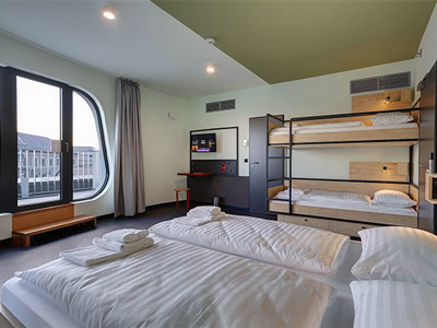 A twin bed with a set of bunkbeds in and a large window at Meininger Budapest Great Market Hall - Rank #1