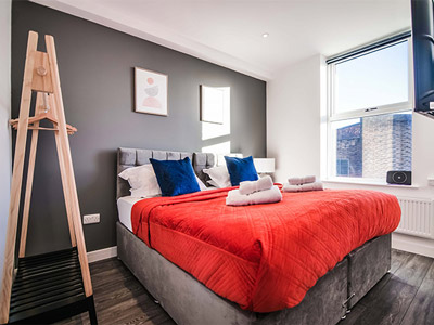 An room with a double bed, an open wardrobe and a TV at York Crescent Apartments