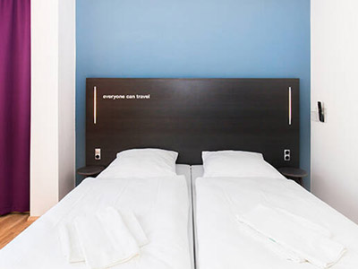 A double bed against a blue wall at a&o Prague Rhea