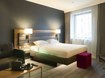 A room with a double bed, sofa and coffee table at Moxy York