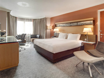 A king bed in a spacious room with a dressing area and sitting area at The Quay Hotel Sheffield