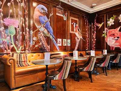 A quirky bar area at the Oddfellows hotel that has animals painted onto wooden panelling 