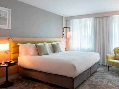 A double bed in a room with warm lighting at The Morgan Hotel 