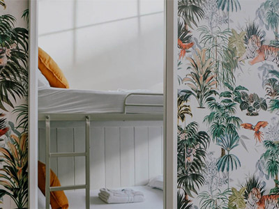 A set of bunkbeds in a mirror reflection on a patterned wall at Gardiner House Hostel 