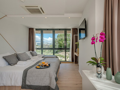 A room with a double bed, single bed and large windows at Hotel Pax