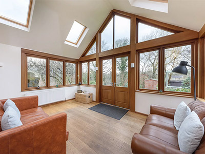 A lounge area with big large windows looking onto the garden at The Old Vicarge
