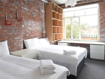 Two double beds in a room with a large window and plenty of storage space at 36 Mason Street