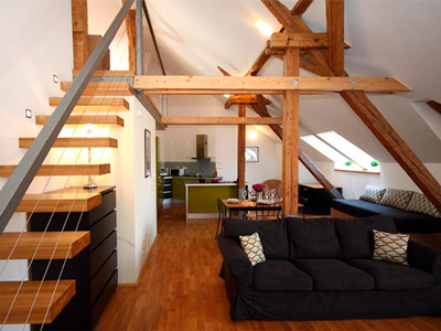An open plan kitchen and living area, with stairs leading up to the bedrooms at Riverview Apartments in Prague