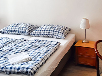 A double bed with checked bedding and a bedside table beside it at A Plus Hotel & Hostel 