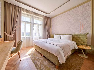 A double bed in a room with a dressing area and large windows at Mamaison Hotel Riverside