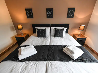 A double bed in a room with black decor at Bird Ith Hand Manor