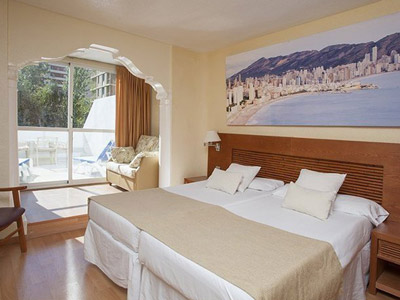 A king bed in a room with a balcony at Magic Villa De Benidorm