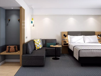 A double bed in an open plan room with a sofa and bathroom at Holiday Inn Blackpool