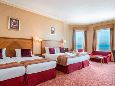 Four beds in a room with large windows that overlook the sea at The Imperial Blackpool