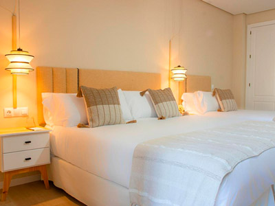 Two beds beside each other with warm lighting and bedside tables at Vive Costa Azul Hotel