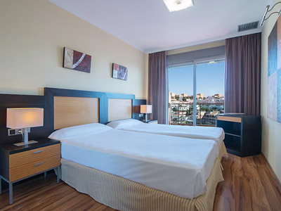 Two beds in a room with a balcony and view of the city at Pierre & Vacances Benalmadena Principe